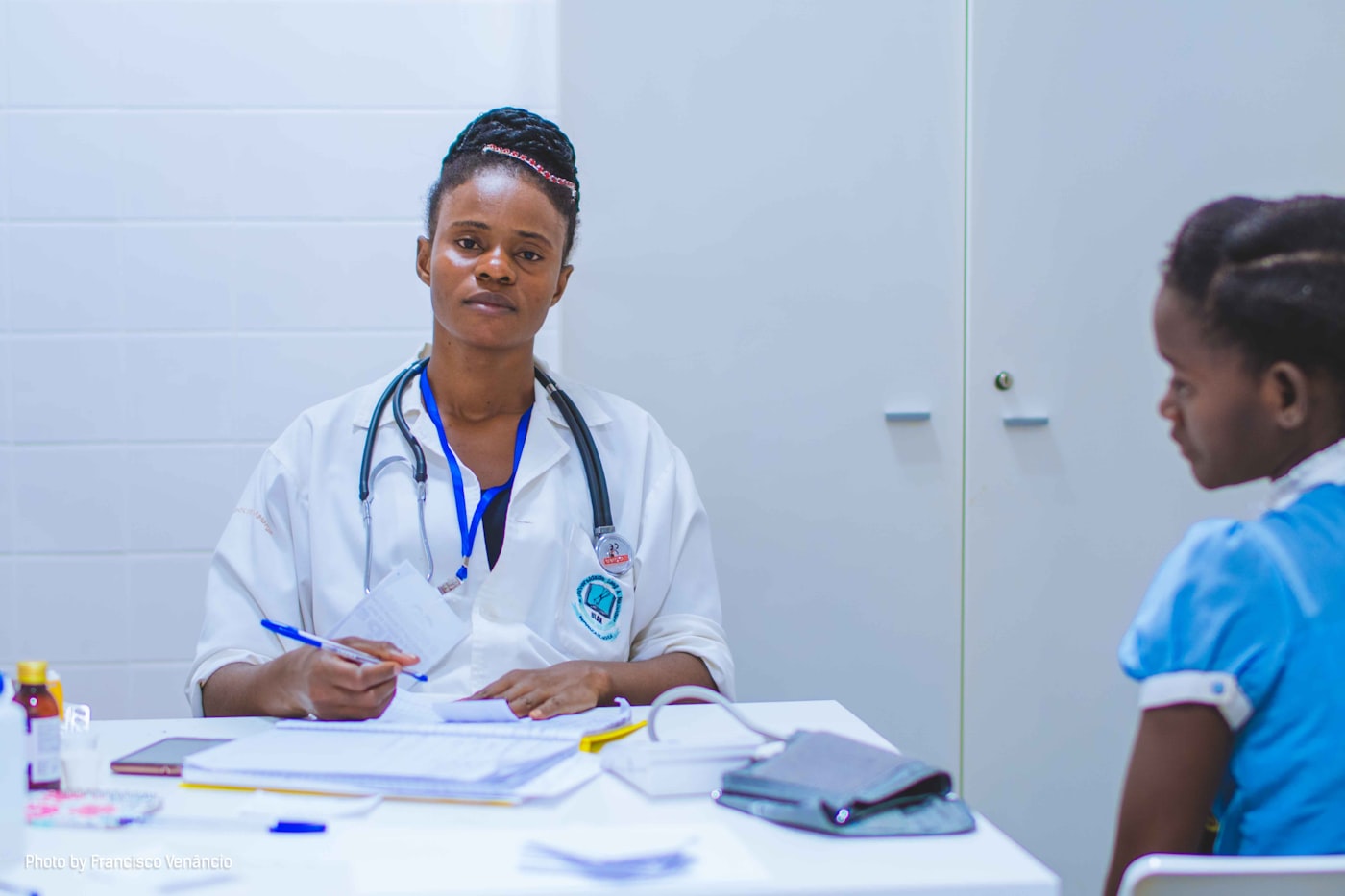 A doctor reviewing notes with a patient in a clinic consulting room